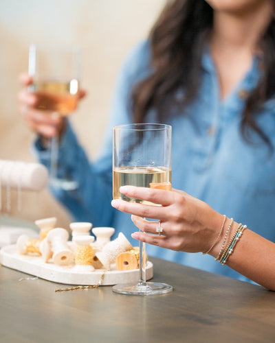 Two women enjoying drinks and jewelry